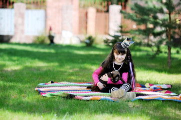 Litlle girl in crown from news paper with her cat outside
