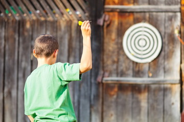 Boy playing darts outdoor