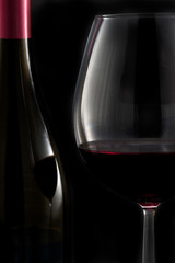 Glass of red wine with bottle