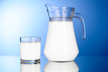 Pitcher and Glass with milk on blue background