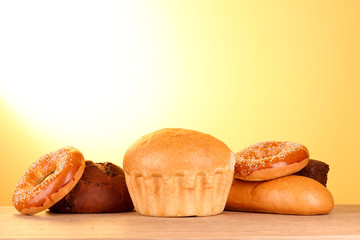 Baked bread assortment on yellow background