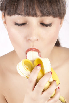 Young woman eating banana