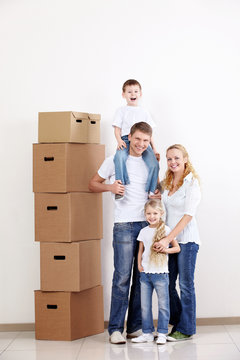 Happy family with boxes indoors