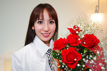 バラの花束を持っている笑顔の女性