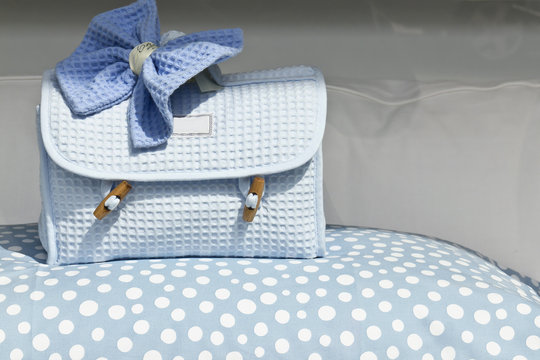 Porta accessori celeste su copriletto a pois