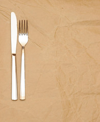 knife and fork on old paper. space for the text