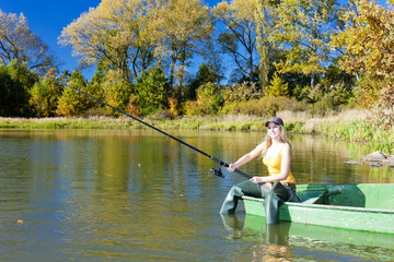 Fototapeta na wymiar Kobieta siedzi na łodzi, wędkarstwo