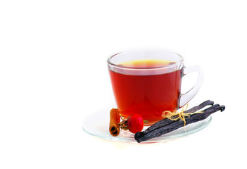 Herbal tea in cup of glass with dog-rose and spices on a white b