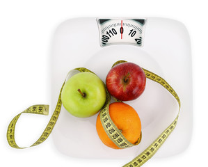 Diet concept. Fruits with measuring tape  on a plate