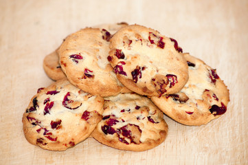 Heap of cranberry cookies on wooden plate