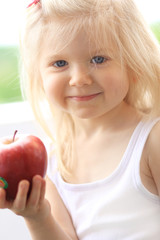 Beautiful smiling girl holding apple