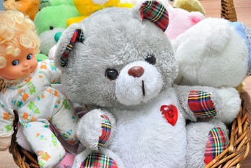Cesto con orsacchiotti di peluche e bambole