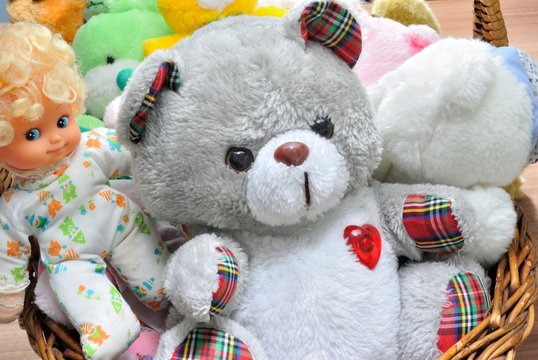 Cesto con orsacchiotti di peluche e bambole