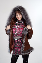 youth woman staning in coat with fur neck isolated