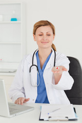 Attractive female doctor showing pills to the camera