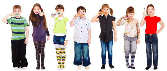 Several kids cleaning teeth or holding toothbrush in hand