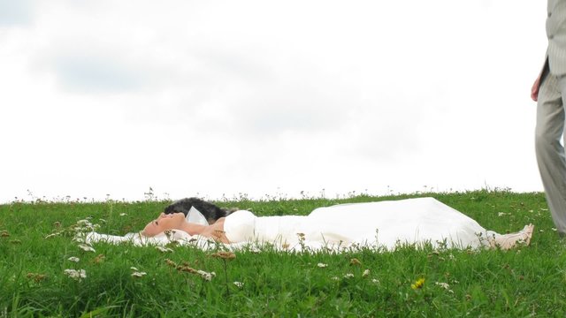 Newlywed pair poses for photographer on grass, time lapse