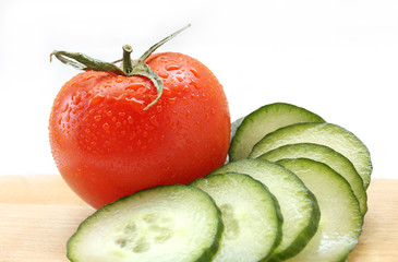 Cucumber and tomato on a wooden board