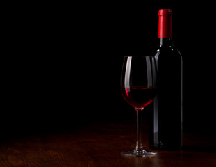 Obraz na płótnie Canvas Kieliszek do wina i butelka na drewnianym stole