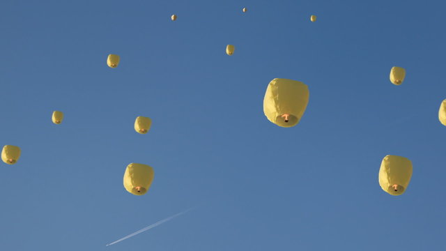high into sky fly chinese lanternes, above them flies airplane