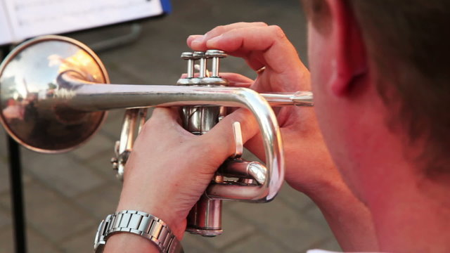 man playing trumpet march music sitting on sunny day