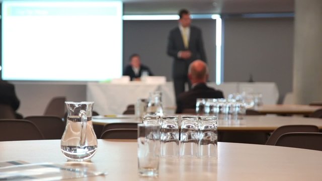 Carafe with water and glasses in conference room