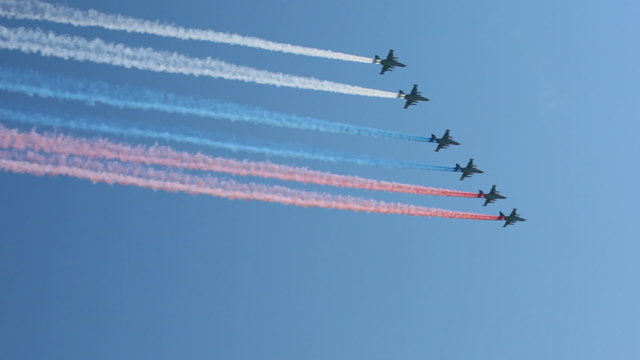planes in sky leaving trail of smoke as tricolor Russian flag