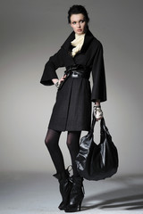Fashion girl with bag posing in the studio