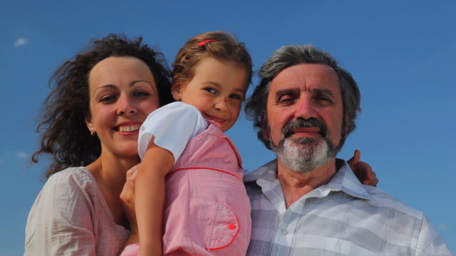 senior, adult daughter with granddaughter on hands