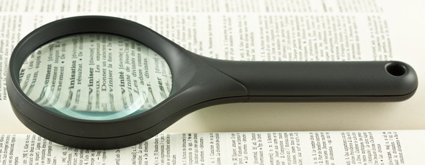 loupe grossissante sur page de dictionnaire