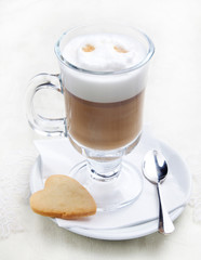 Glass of coffe with cookie on white plate