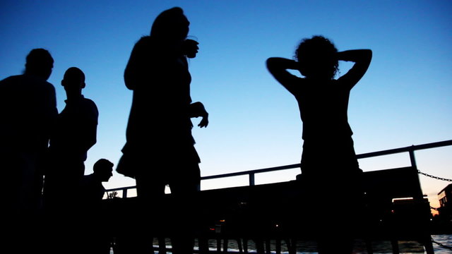 silhouettes of girls dancing on board ship sailing against sky