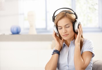 Fototapeta premium Young female enjoying music eyes closed
