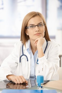 Young medical student sitting at desk in office
