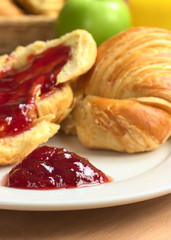 Strawberry jam on plate with croissant