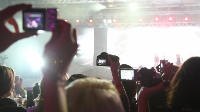 Close-up of people who look concert and records it on camera