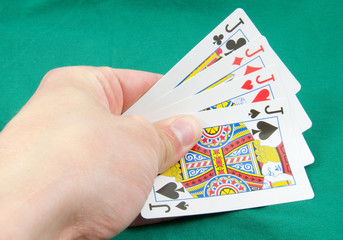 four jacks in hand on card table