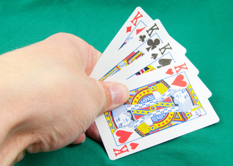 four kings in hand on card table