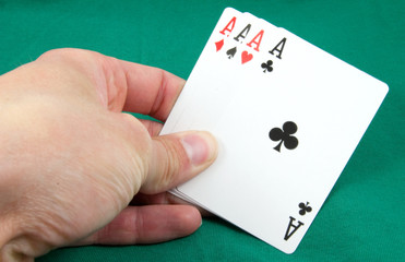 four aces in hand on green card table