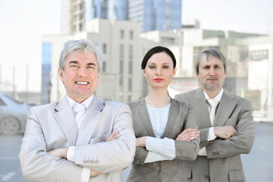 Portrait of three business people outside.