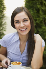 Closeup portrait of cute young woman sitting and smiling in the