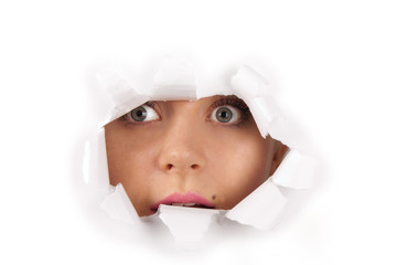 Young woman looking through hole in a paper