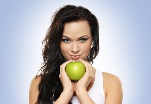 Portrait of a young and attractive woman holding a green apple