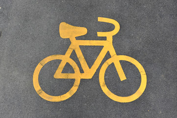 Naklejka premium Yellow Bicycle Sign On Tarmac Indicating Bicycle Lane
