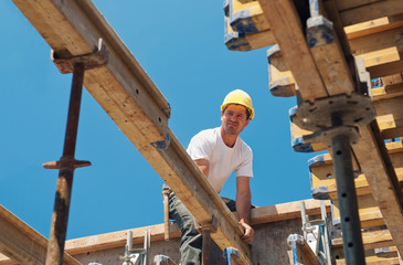 Construction worker placing formwork beams - 32300155