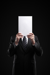 Business man in dark suit holding a blank sign