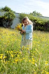 Fototapeta premium Mädchen pflückt einen Blumenstrauss für Mama