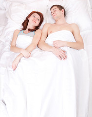 young beautiful couple sleeping in bed