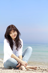 Fototapeta na wymiar Young beautiful brunette girl at the beach in spring time. Outdo