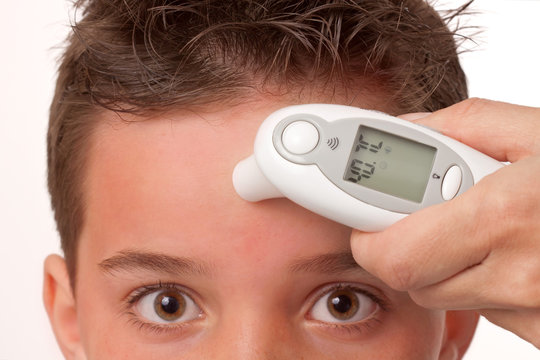 Fieber messen mit Stirnthermometer bei einem Jungen - Kind